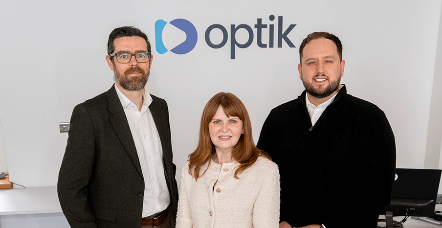 Steven Scullion Director of Corporate Finance at Invest NI, Minister for the Economy Dr Caoimhe Archibald, and Ciaran Ryan, CEO of Optik AI are standing in Optik AI's office