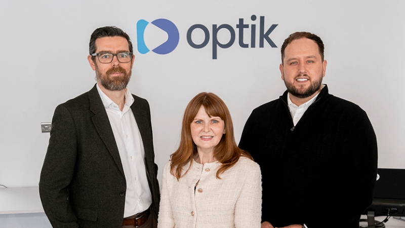 Steven Scullion Director of Corporate Finance at Invest NI, Minister for the Economy Dr Caoimhe Archibald, and Ciaran Ryan, CEO of Optik AI are standing in Optik AI's office